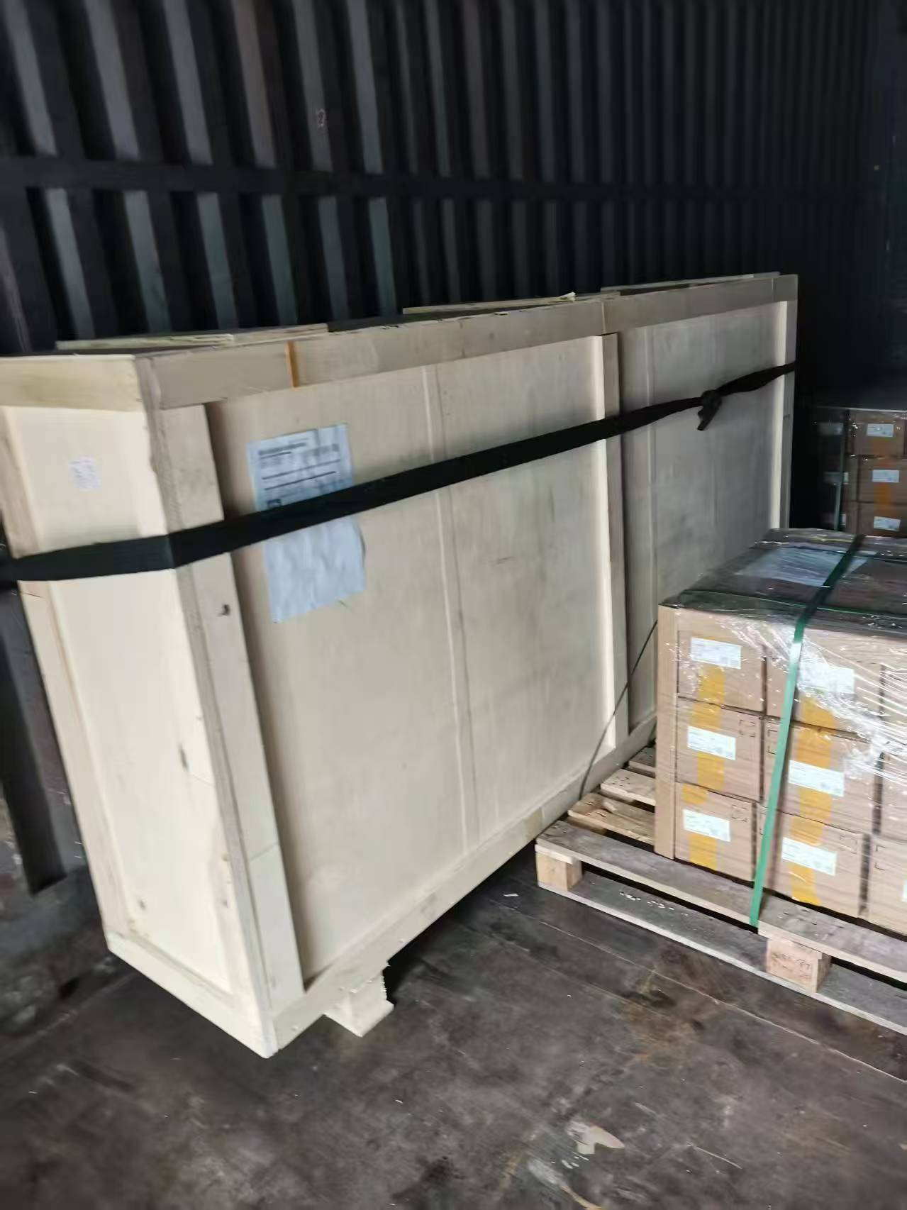 Plywood-cased cargo strapped and braced inside a shipping container