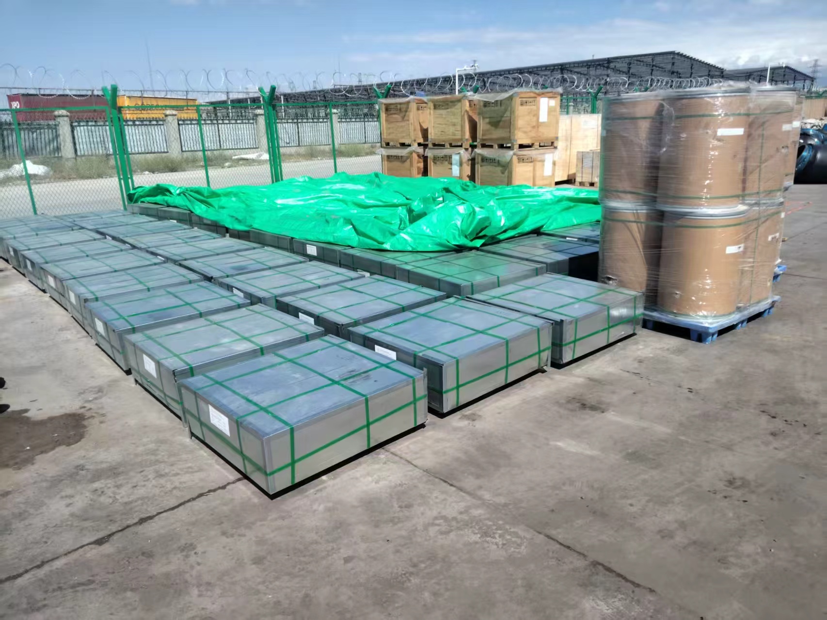 Metal sheet bundles wrapped and staged in the yard before loading